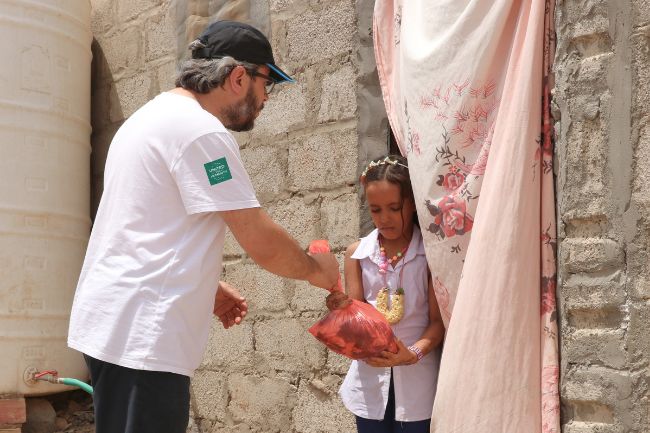 Ein Mädchen erhält Kurban in Syrien von einem humanitären Helfer.